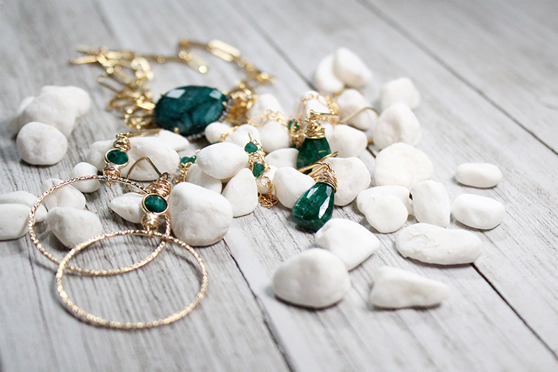 Emerald Jewelry on Display with white rocks | Bloom Jewelry