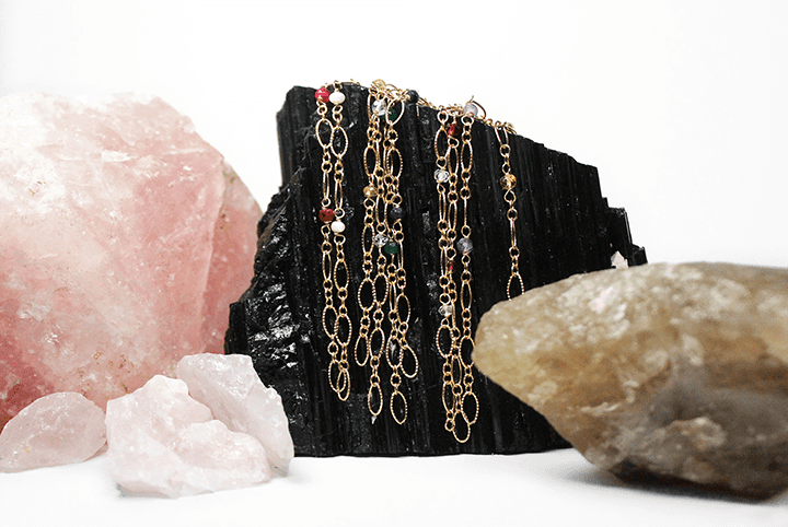 Birthstone bracelets laying on rock.